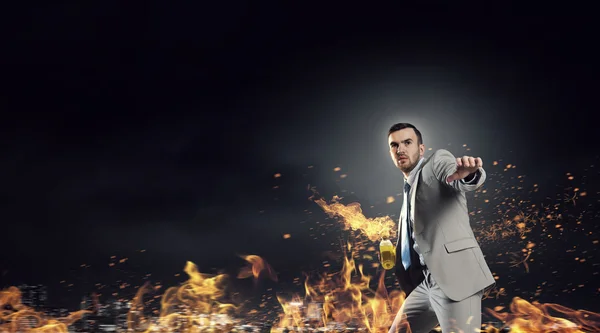 Businessman throwing petrol bomb . Mixed media — Stock Photo, Image