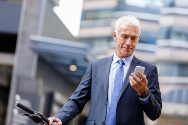 Cep telefonu ile bisiklet üzerinde başarılı iş adamı