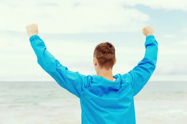 Young man in sport wear with outstretched arms — Stock Photo, Image