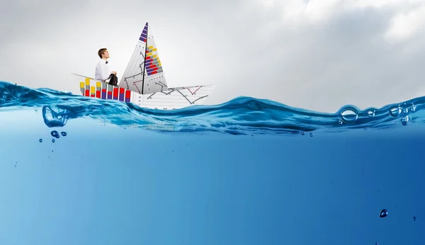 Бізнесмен плаває на паперовому кораблі. Змішані носії — стокове фото
