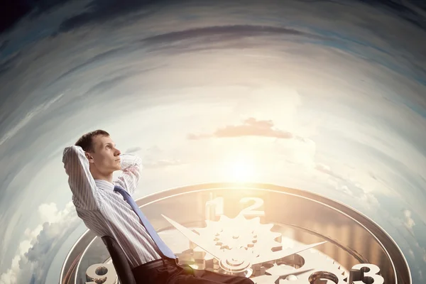 Businessman relaxing in his chair . Mixed media — Stock Photo, Image