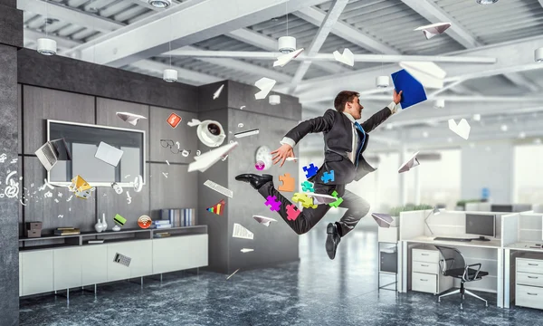 Прыгающий бизнесмен в офисе. Смешанные медиа — стоковое фото