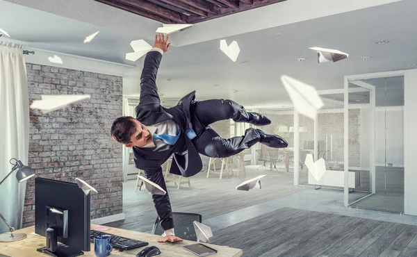 Jumping businessman in office . Mixed media — Stock Photo, Image