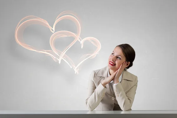 Businesswoman sitting at desk . Mixed media — Stock Photo, Image