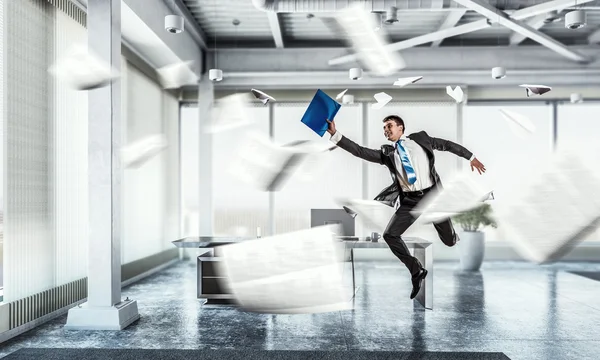 Jumping businessman in office . Mixed media — Stock Photo, Image