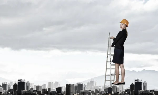 Builder woman viewing city . Mixed media — Stock Photo, Image