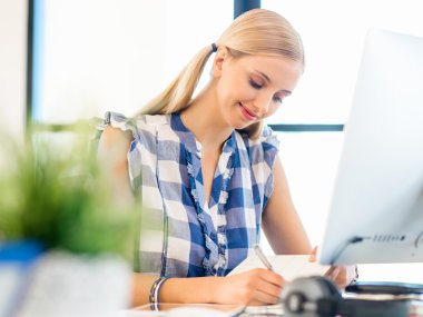 Genç bayan ofiste çalışıyor.