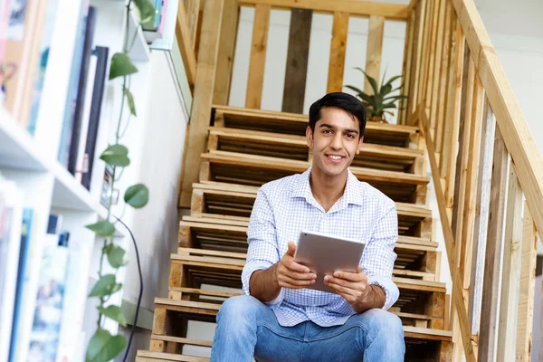 Porträt eines jungen Mannes, der im Büro an der Treppe sitzt — Stockfoto