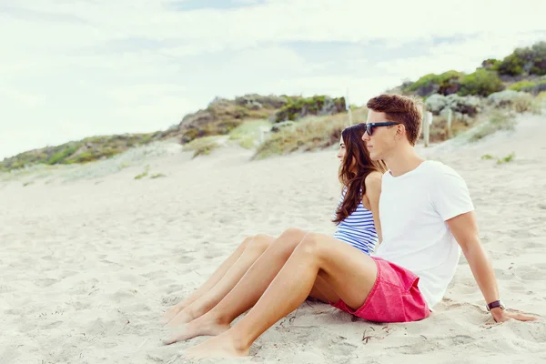 Romantico giovane coppia seduta sulla spiaggia — Foto Stock