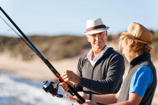 Uomo anziano pesca con suo nipote — Foto Stock