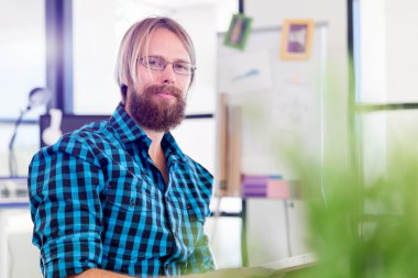 Genç adam ofiste çalışıyor.