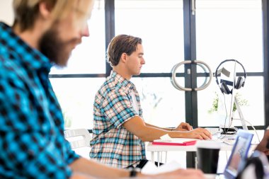 Genç adam ofiste çalışıyor.