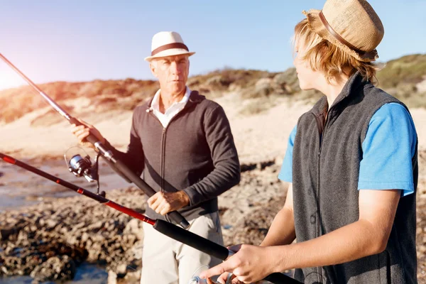 Uomo anziano pesca con suo nipote — Foto Stock