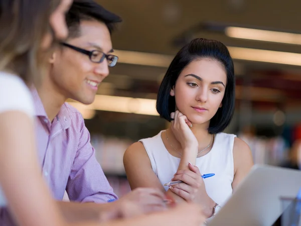 Group of young students at the library — Stock Photo, Image