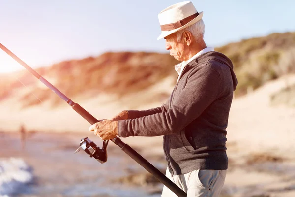 Hombre mayor pescando en el lado del mar — Foto de Stock