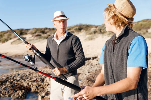 Uomo anziano pesca con suo nipote — Foto Stock