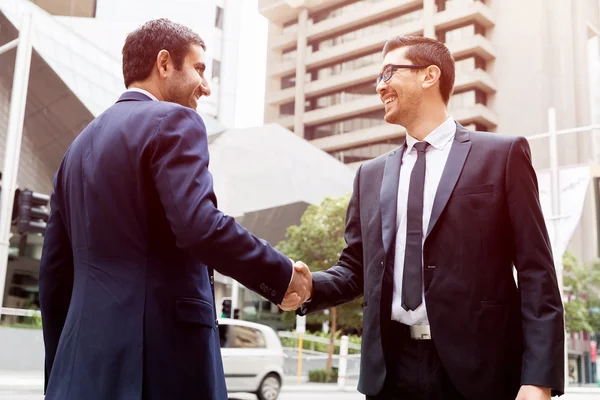 Dos hombres de negocios estrechando sus manos — Foto de Stock