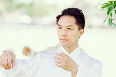 Yakışıklı adam Thai Chi yapıyor.