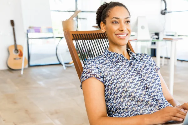 Afro-Amerikan ofis çalışanı iş içinde oturan gülümseyen portresi — Stok fotoğraf