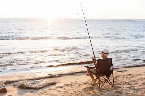 Senior man fishing at sea side — Stock Photo, Image