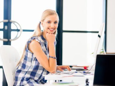 Genç bayan ofiste çalışıyor.