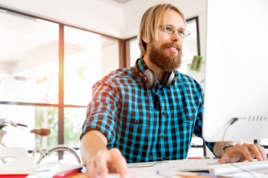 Genç adam ofiste çalışıyor.