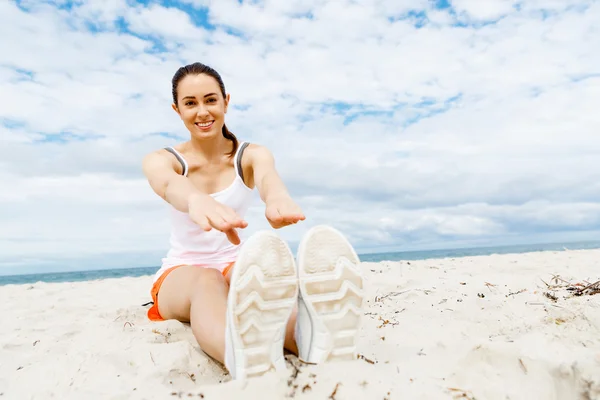 Mujer joven entrenando en la playa afuera —  Fotos de Stock