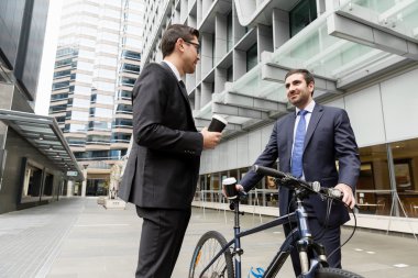 İki genç işadamları ile bir bisiklet şehir merkezinde
