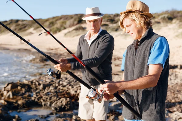 Uomo anziano pesca con suo nipote — Foto Stock