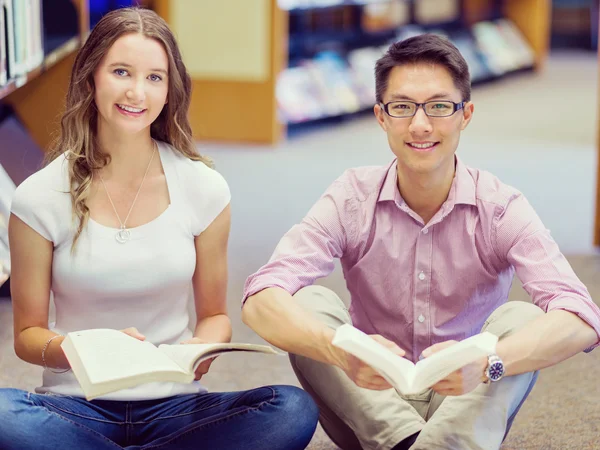 Dos jóvenes estudiantes en la biblioteca —  Fotos de Stock