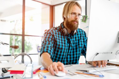 Genç adam ofiste çalışıyor.