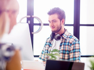 Genç adam ofiste çalışıyor.