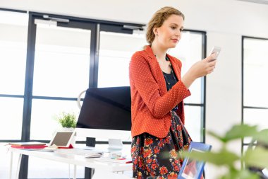 Ofiste cep telefonu tutan genç kadın