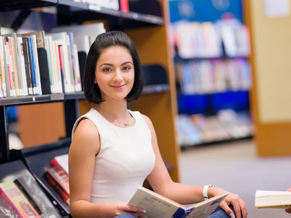 Gelukkig vrouwelijke student in de bibliotheek — Stockfoto