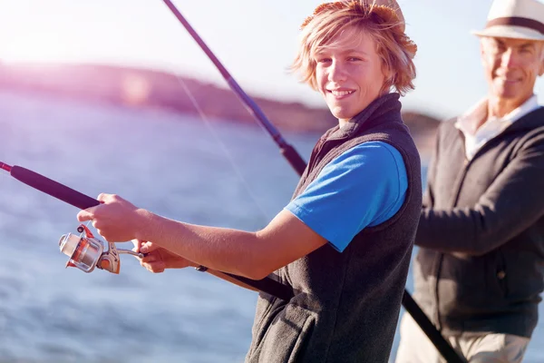 Uomo anziano pesca con suo nipote — Foto Stock