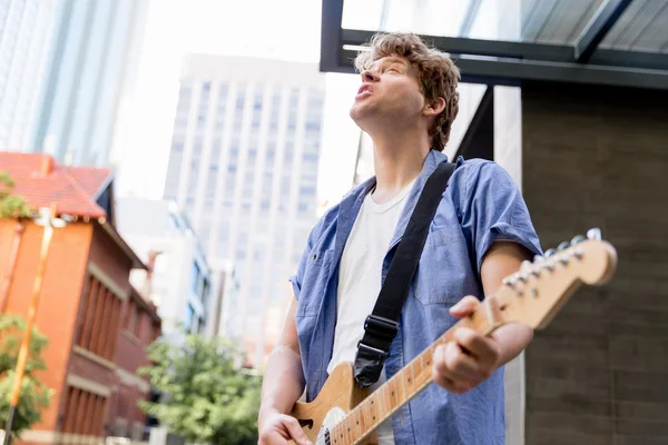 Young musician with guitar in city — Stock Photo, Image