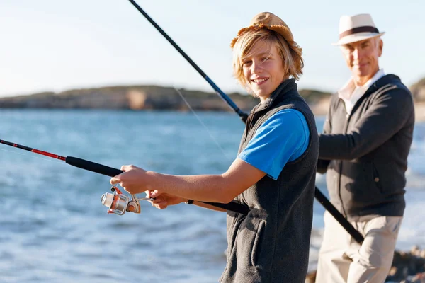 Hombre mayor pescando con su nieto — Foto de Stock