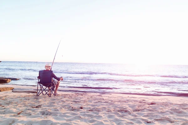 Senior man fishing at sea side — Stock Photo, Image