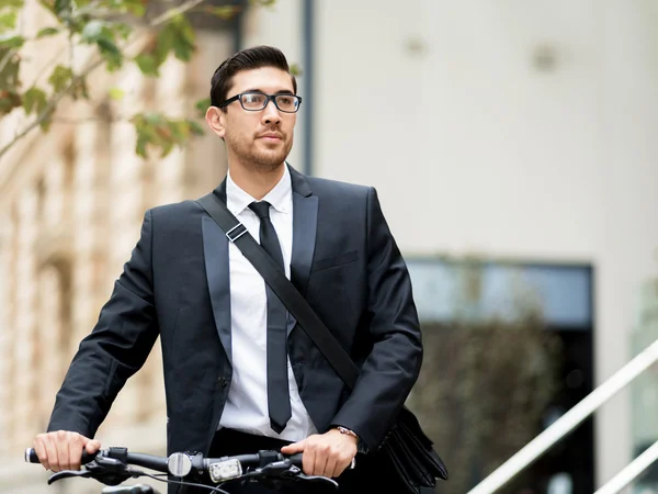 Homens de negócios jovens com uma bicicleta — Fotografia de Stock