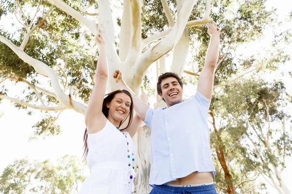 Pareja joven en el parque celebrando — Foto de Stock