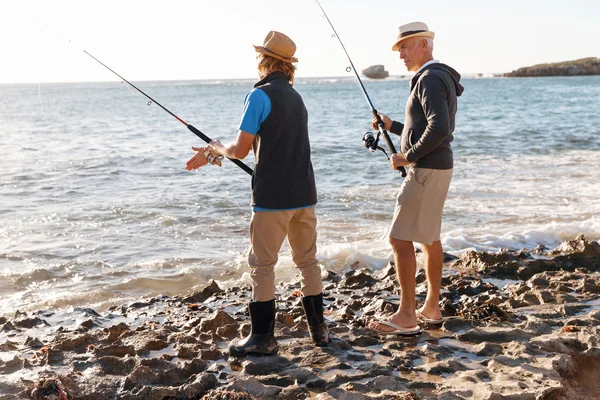 Uomo anziano pesca con suo nipote — Foto Stock