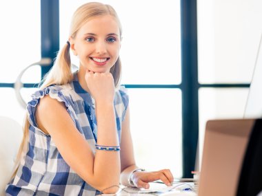 Genç bayan ofiste çalışıyor.