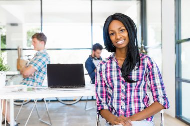 Afro-Amerikan ofis çalışanı iş içinde oturan gülümseyen portresi