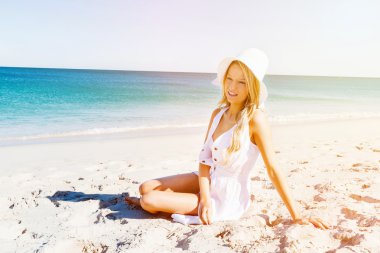 Genç bir kadın sahilde dinleniyor.