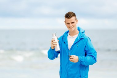 Şişe su ile tutarak kendine güvenen genç adam