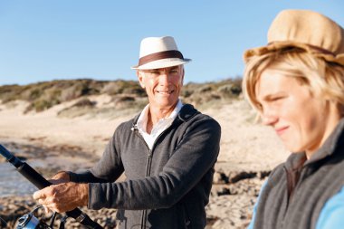 Yaşlı adam torunuyla balık tutuyor.