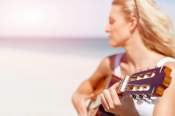 Piękna młoda kobieta gra na gitarze na plaży — Zdjęcie stockowe