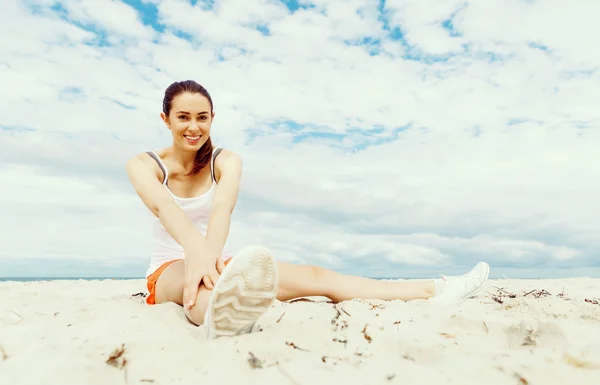 Junge Frau trainiert draußen am Strand — Stockfoto