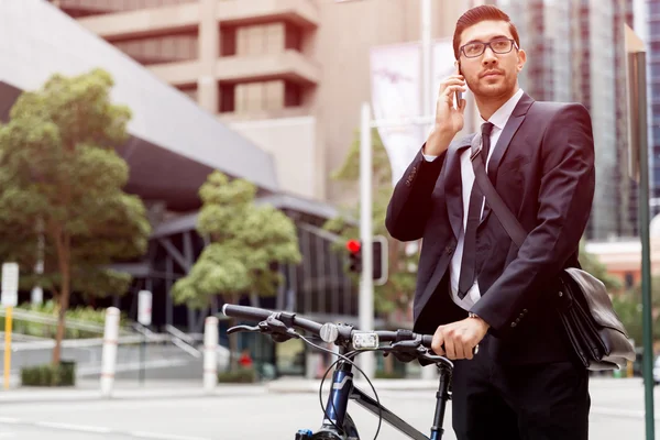 Homens de negócios jovens com uma bicicleta — Fotografia de Stock
