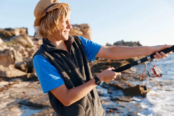 Tiener jongen vissen op zee — Stockfoto